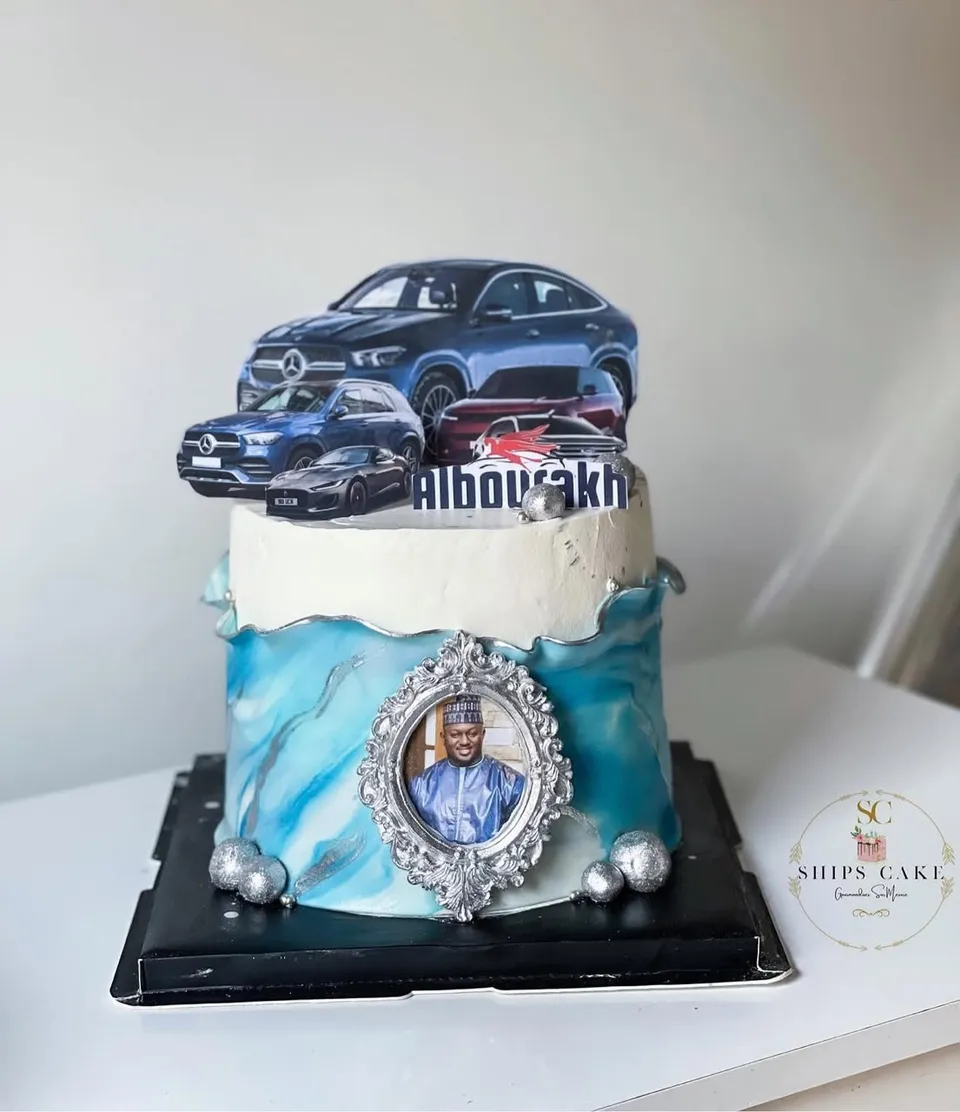 Blue marbled cake decorated with cars, a photo medallion and silver pearls