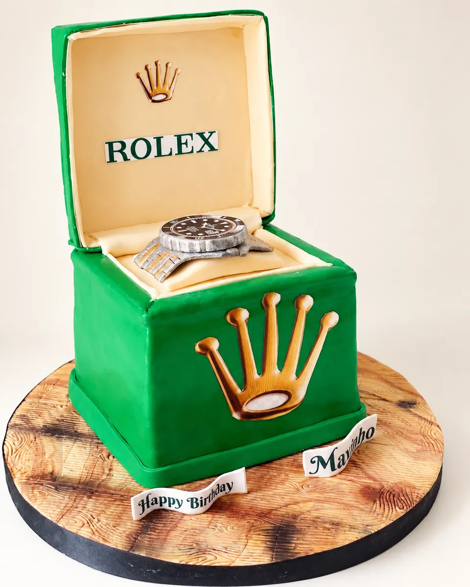 Cake sculpted as a green watch box, with a sugar wristwatch inside