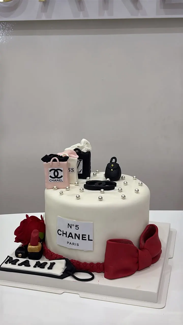 Elegant white cake with pearls and a red fondant bow