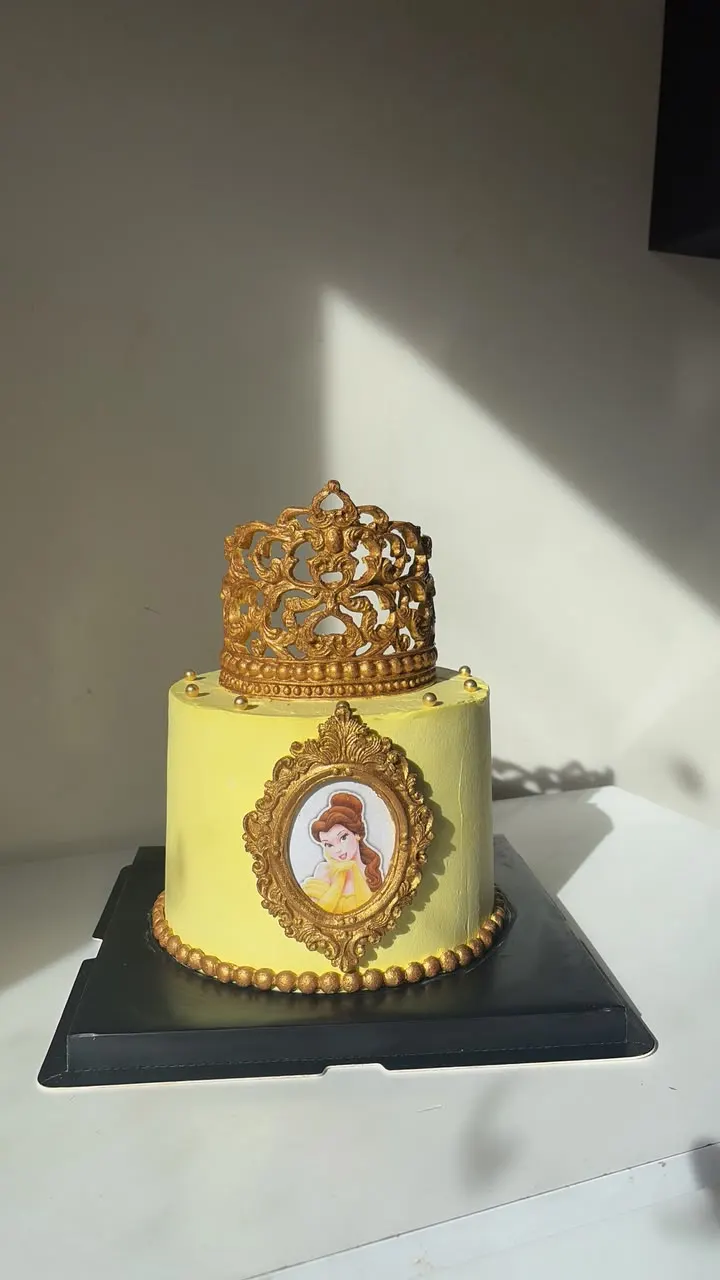 Yellow and gold cake with a crown and a gilded photo frame