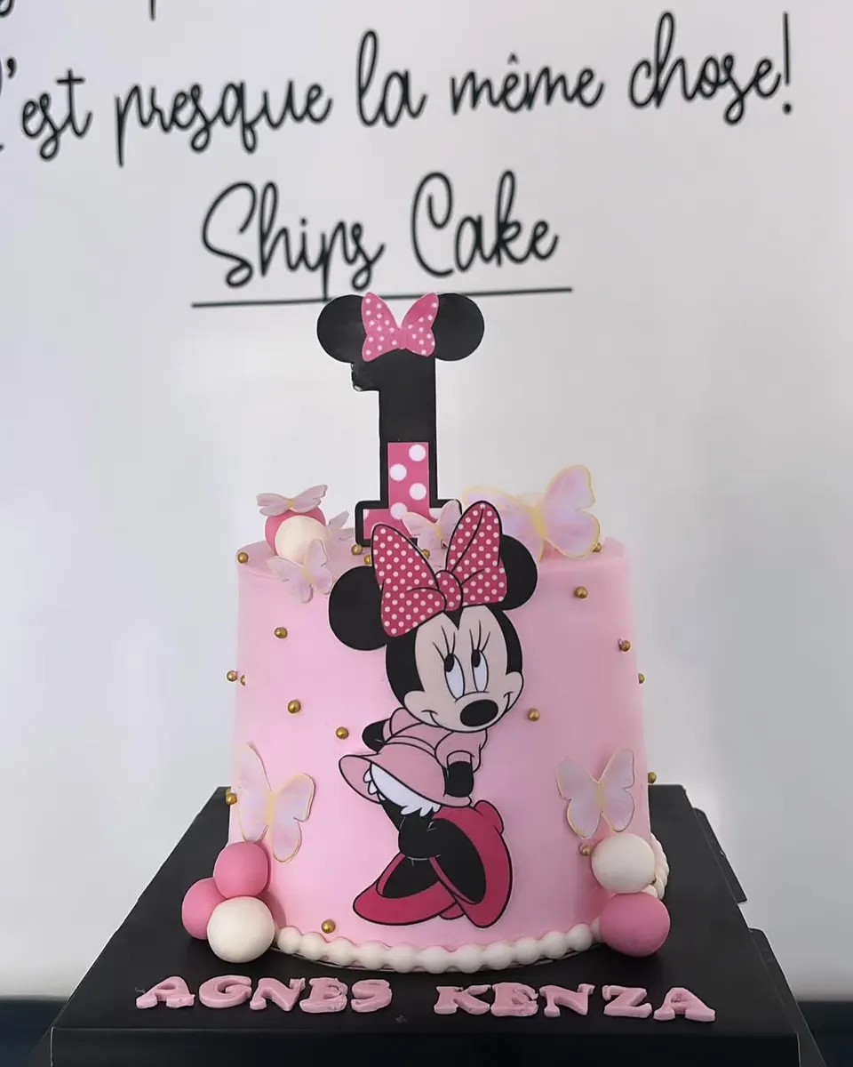 Pink cake decorated with Minnie, pearls and a bow, with the child's name