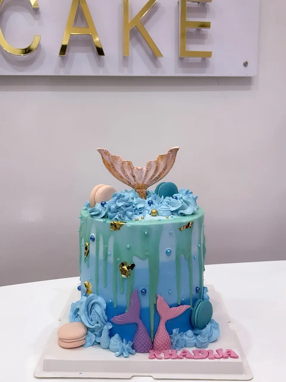 Blue and green mermaid cake with a golden tail and sugar shells