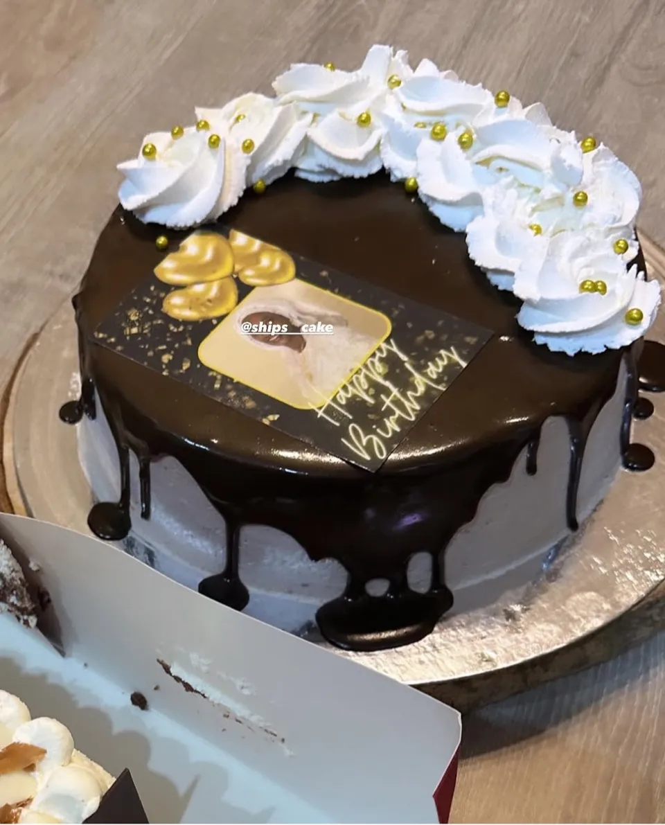 Ganache-topped cake with a crown of whipped cream and gold pearls
