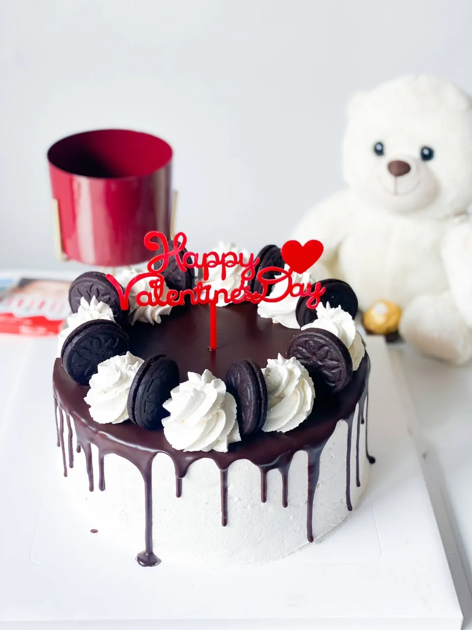 White buttercream cake with a dark chocolate drip, whipped cream and Oreo biscuits