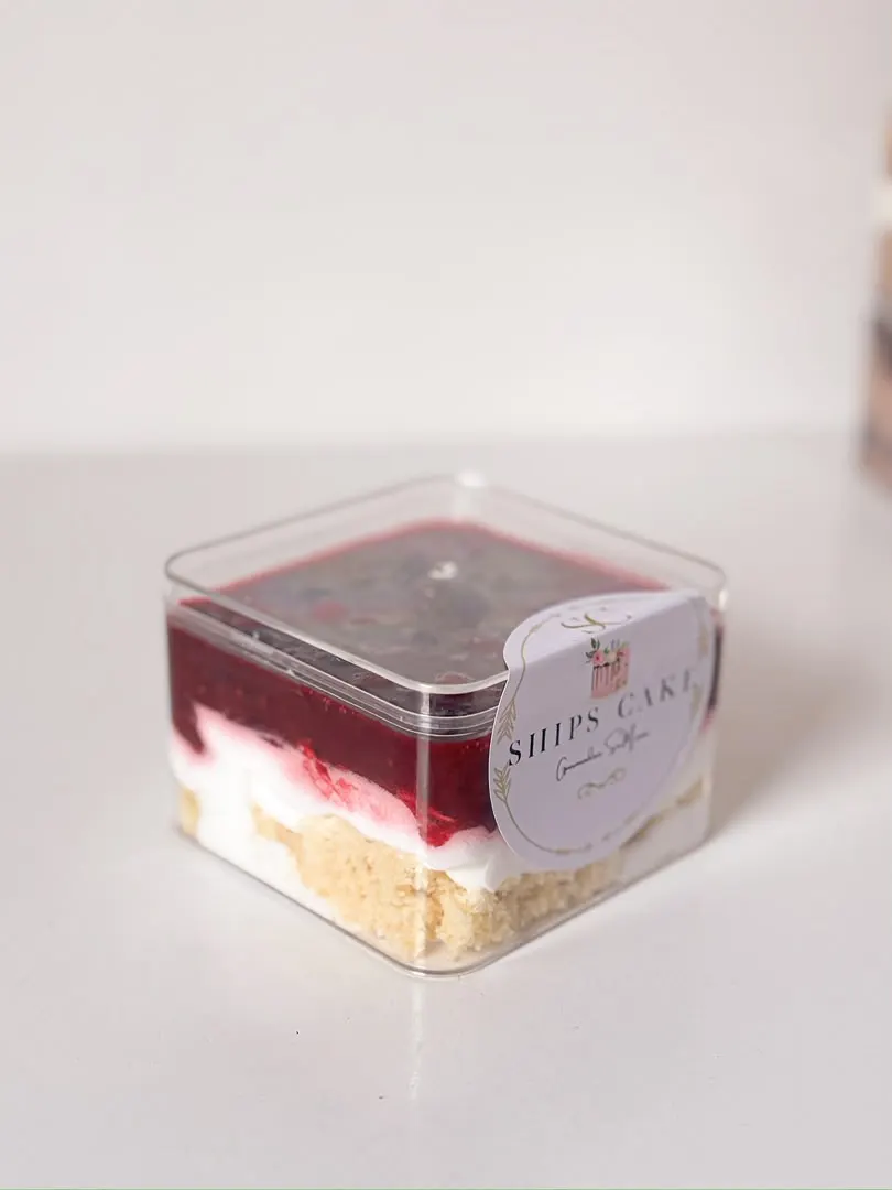 Individual raspberry dessert cup with cream and biscuit base